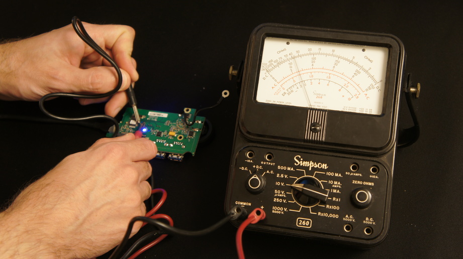 A person using an electronic voltage measuring tool